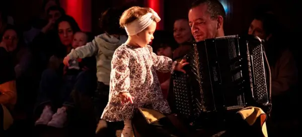Bebés y padres disfrutando de un concierto con instrumentos musicales.