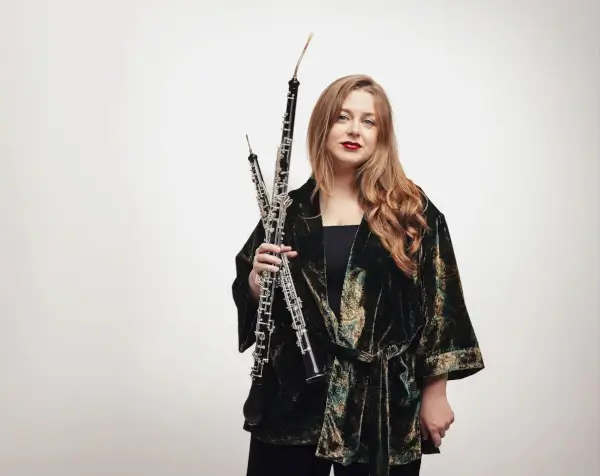 La oboísta Iria Folgado interpretando un solo con la Real Filharmonía de Galicia y el director Baldur Brönnimann en el escenario.