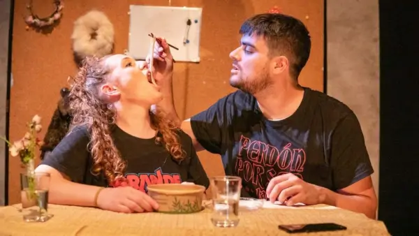 Escena de la obra 'Cortello de Amor' de Amorodio Teatro, mostrando a una pareja en un desván o espacio reducido.