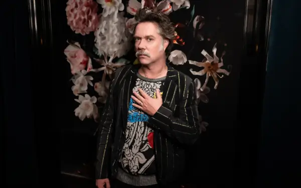 Rufus Wainwright cantando en el escenario junto a la Real Filharmonía de Galicia, con instrumentos de cuerda y viento.