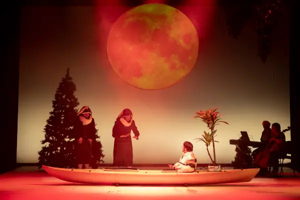 Actores en escena con máscaras y vestuario evocador, en un ambiente que sugiere los paisajes nórdicos y la aurora boreal, con elementos de danza.