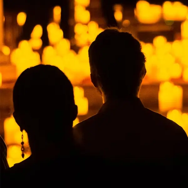 Un cuarteto de cuerda tocando instrumentos bajo la suave luz de numerosas velas, creando una atmósfera íntima y musical.