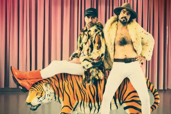 Dos actores, Dani Blanco y Alberte Bello, en escena con vestuario llamativo, riendo y gesticulando durante la comedia 'Less Dragqueens and more Chunorris!'
