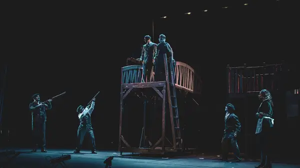 Escena de la obra 'La balada del norte' de Saltantes Teatro, mostrando personajes en un ambiente minero con vestuario de época.